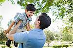 Mixed Race Father and Son Playing Together in the Park.