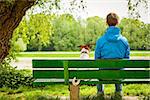 dog sitting on a bank with owner and enjoying the view