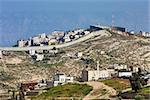 Small village and palestinian town on the hill behind israeli separation barrier on the West Bank in Israel.