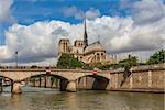 View of famous Notre Dame de Paris Cathedral under beautiful cloudy sky in Paris, France.