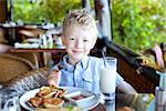 cheerful little boy ready for his breakfast at the resort
