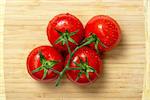 Top view of fresh tomatoes on wooden chopping board