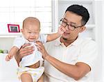 Asian family lifestyle at home. Father playing with his baby boy.
