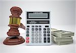 Gavel, wads money and calculator. The gray background