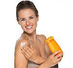 Happy young woman applying sun screen creme