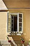 old opened window with flowerpots