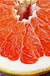 Background of Fresh Juicy Red Grapefruit Slice Cross Section closeup