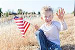 cute little boy holding american flag and celebrating independence day