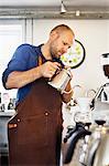 Male barista pouring boiling water into coffee filter