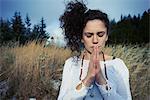 Mid adult woman meditating in forest