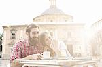 Young couple having coffee in sidewalk cafe, Plaza de la Virgen, Valencia, Spain