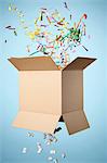 Studio shot of cardboard box with streamers exploding out