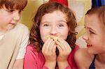 Girl eating party food, friends watching