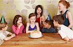 Children at birthday party, girl with cake