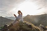 Portrait of a mid adult woman backpacker using smartphone, Achensee, Tyrol, Austria