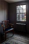 Period chair in corner of basement room, Whitechapel, London