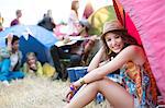 Portrait of woman sitting at front of tent at music festival