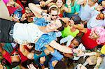 Performer with microphone crowd surfing at music festival