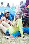 Portrait of woman hanging out with friends outside tents at music festival