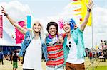 Portrait of cheering friends in wigs at music festival