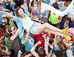 Woman crowd surfing at music festival