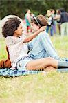 Couple hugging on blanket in grass at music festival