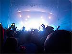 Silhouette of crowd facing stage at music festival