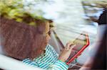 Girl using digital tablet in back seat of car