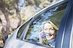 Senior woman talking on cell phone in car