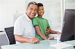 Portrait of smiling grandfather and grandson at computer