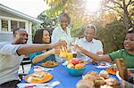 Happy family toasting juice glasses at patio table