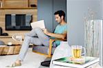Man reading newspaper in living room