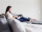 Woman reading magazine on chaise lounge