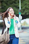 Happy businesswoman talking on cell phone in crosswalk