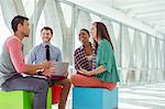 Creative business people meeting on colorful stools