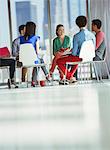 Creative business people meeting in circle of chairs