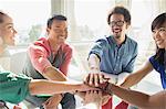 Creative business people connecting hands in huddle