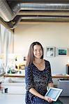 Portrait of smiling businesswoman with digital tablet in office