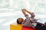 Casual businesswoman laying on bench and text messaging with cell phone