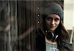 Portrait of teenage girl outdoors, wearing hat and headphones around neck, Germany