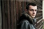 Close-up of young man wearing jacket outdoors, looking at camera, Germany