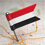 Small Flag of Yemen on a Map Background with Selective Focus.