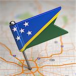 Small Flag of Solomon Islands on a Map Background with Selective Focus.