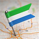 Small Flag of Sierra Leone on a Map Background with Selective Focus.