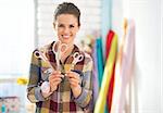 Happy seamstress showing scissors