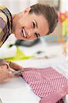 Happy seamstress cutting fabric