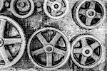 Closeup image of rusted gears hanging on the wall of an abandoned workshop