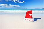 Christmas red Santa Hat on a sunny pristine beautiful beach in Australia
