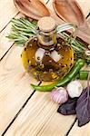 Herbs, spices and seasoning with utensils over wooden table background with copy space