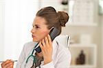 Portrait of medical doctor woman talking phone